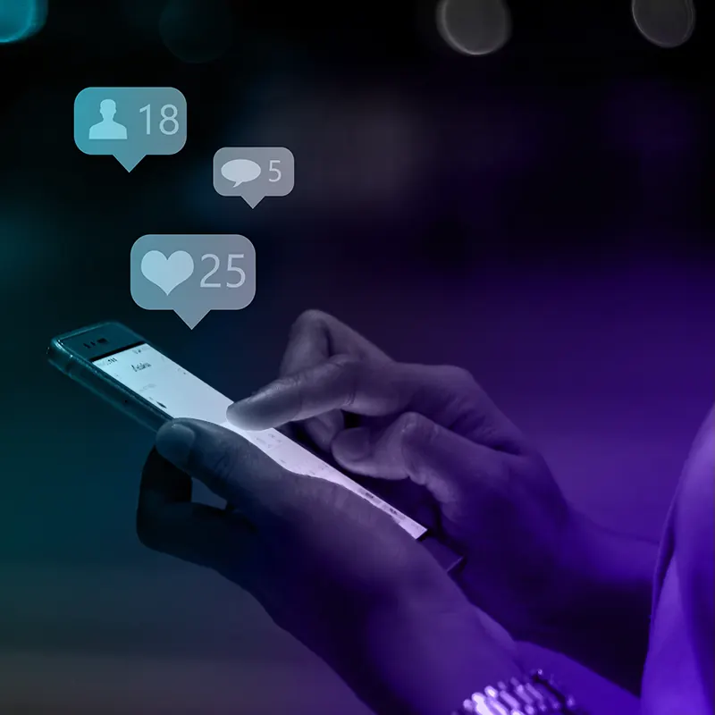 Mãos segurando um celular com notificações de curtidas e comentários